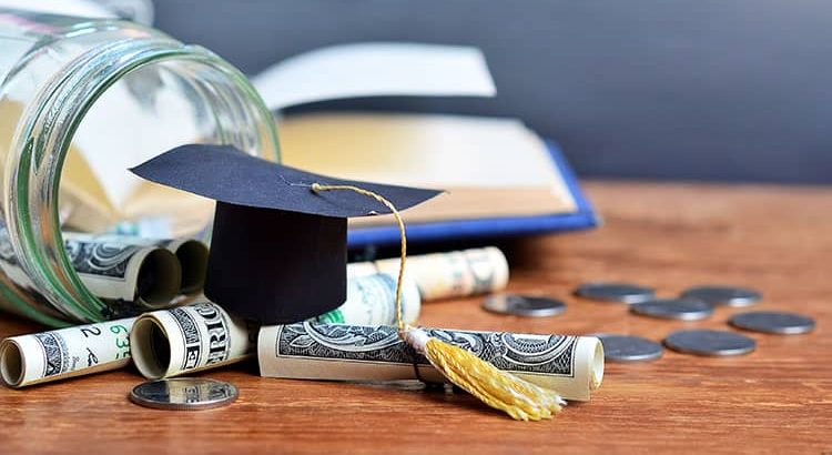 A graduation cap sitting on American money